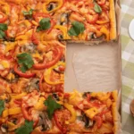 Freshly baked square pizza with crispy crust and melted cheese, sliced and ready to serve.