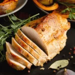 Smoked chicken breast recipe on a grill grate with golden-brown skin and grill marks