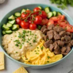 smoked queso recipe dip in a cast iron skillet on a grill, with melted cheese, tomatoes, and jalapeños